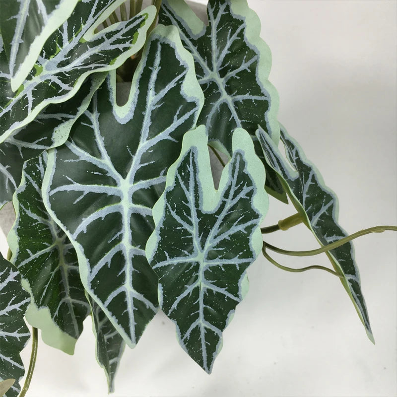 Vigne artificielle murale, ornée de feuilles de paon, de feuilles de tortue et de bégonias vertes.